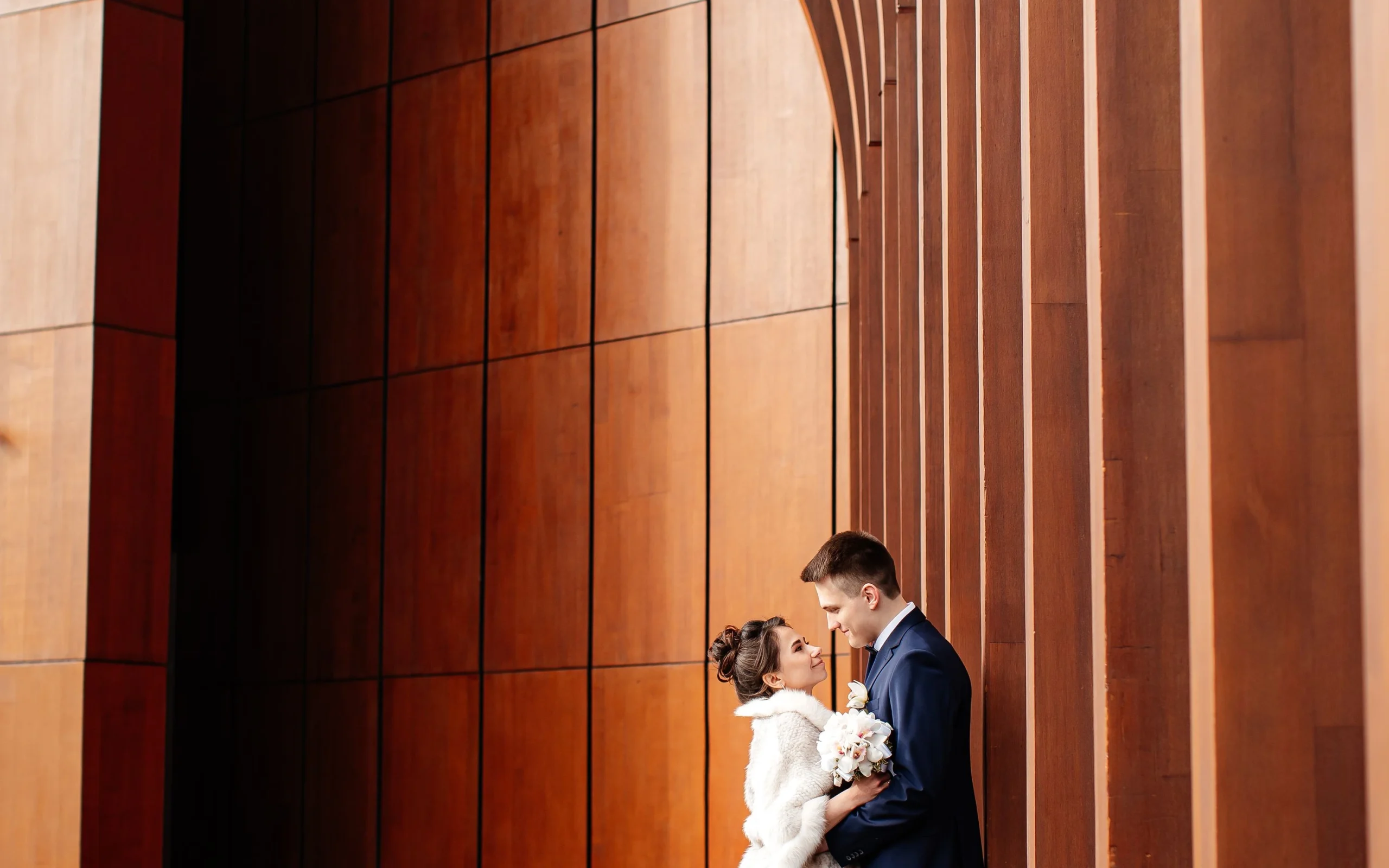 Couple marié devant une architecture en bois